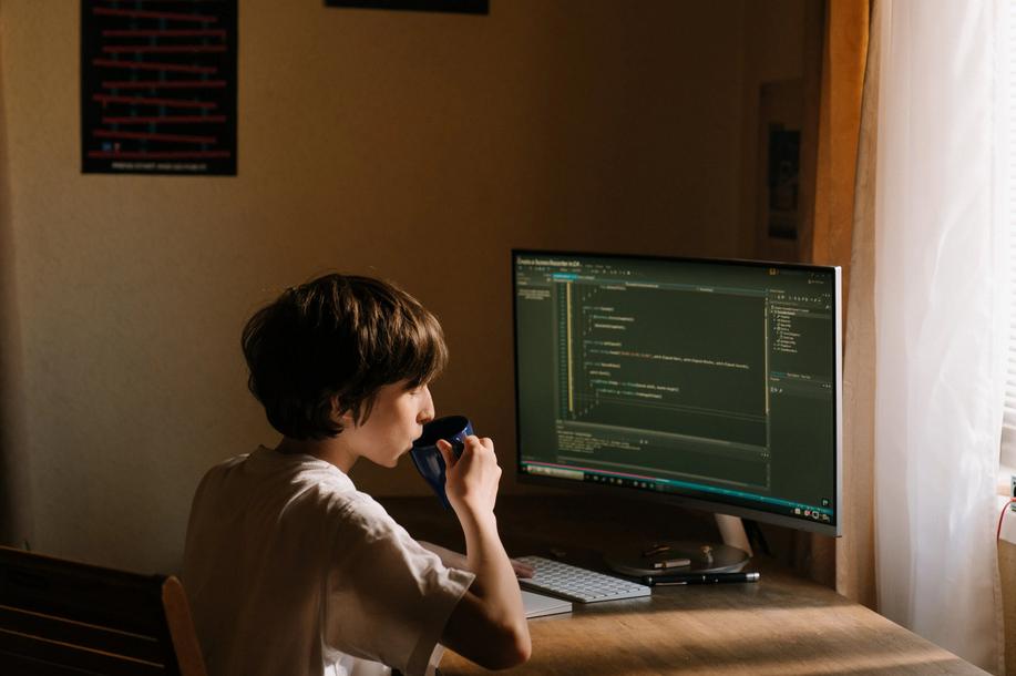 A boy sitting on chair in front of a computer